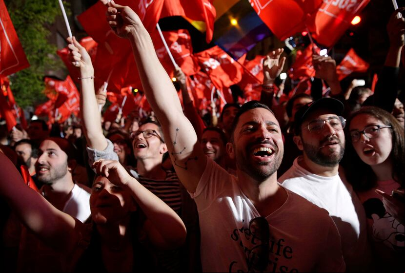 Partidarios de Pedro Sánchez, jefe del gobierno español y candidato del PSOE, festejan al enterarse de los resultados de los comicios en Madrid, el domingo 28 de abril de 2019. (AP / Andrea Comas)