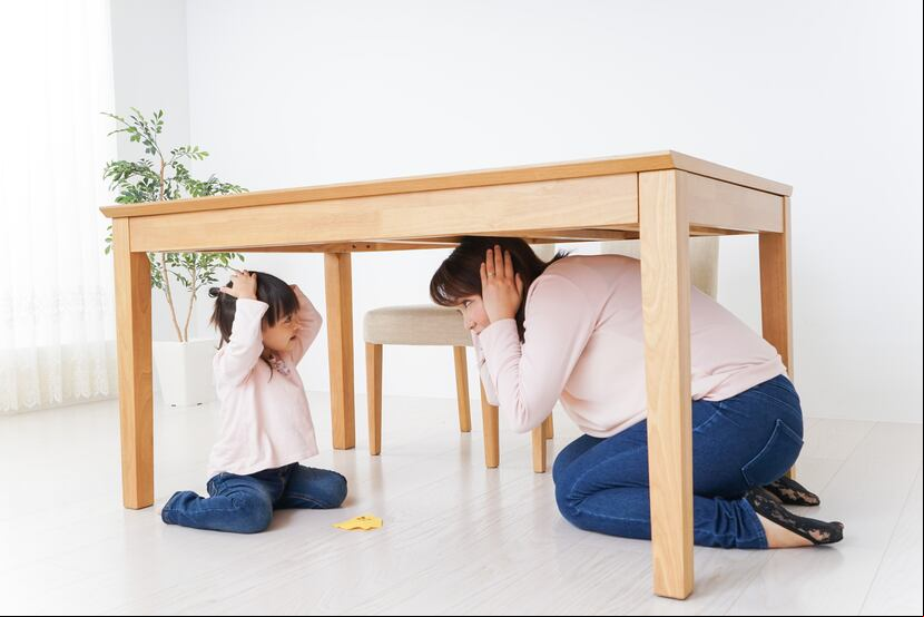 Madre e hija practican cómo protegerse durante un terremoto.